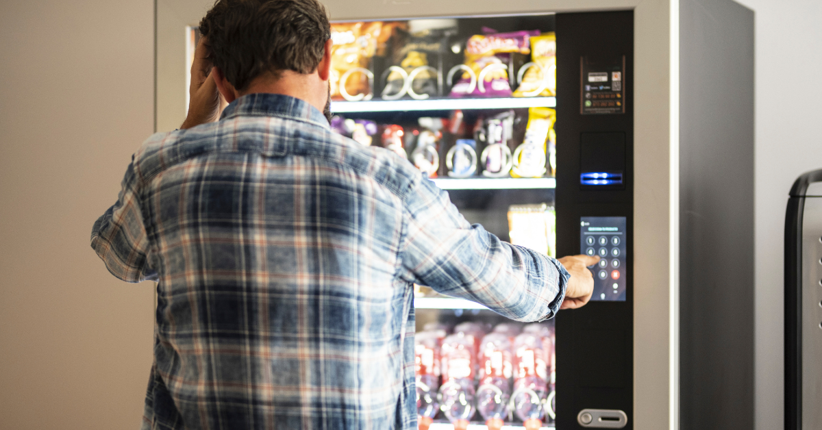 Customer experiencing frustration while using a vending machine with slow response times and delayed touchscreen input.