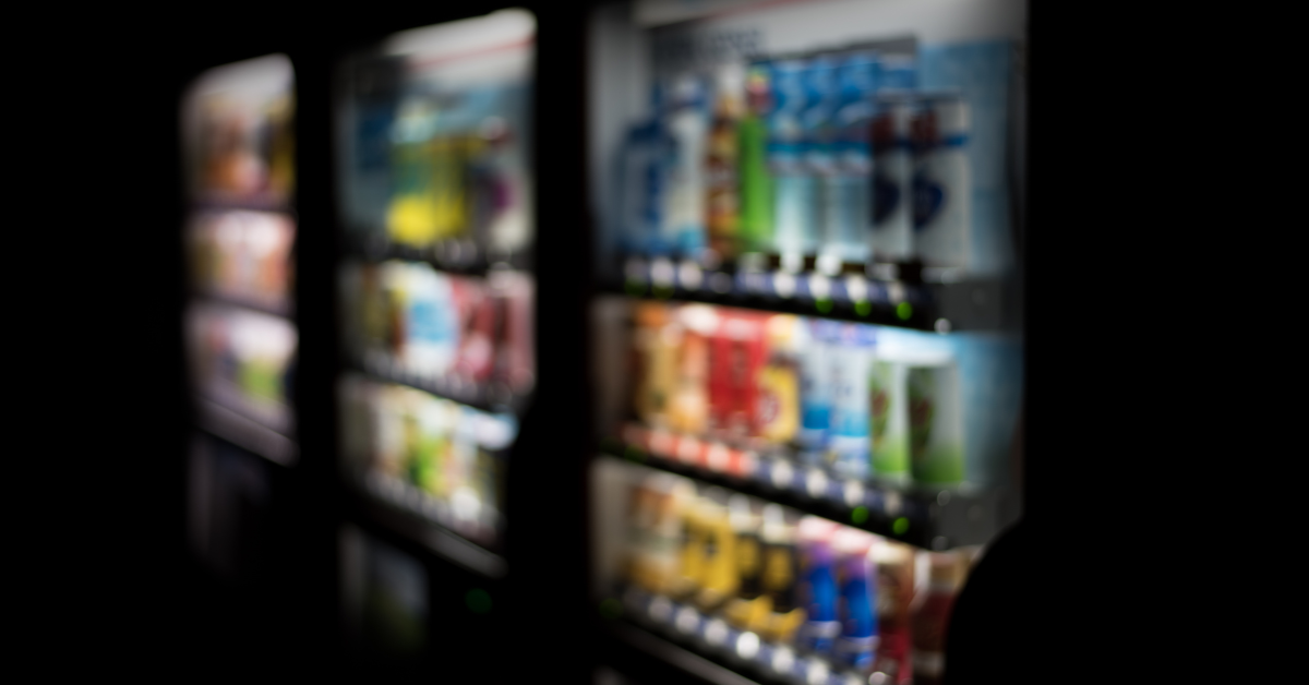 Beverage vending machine with weak interior lighting, making drinks difficult to see and reducing product visibility for customers