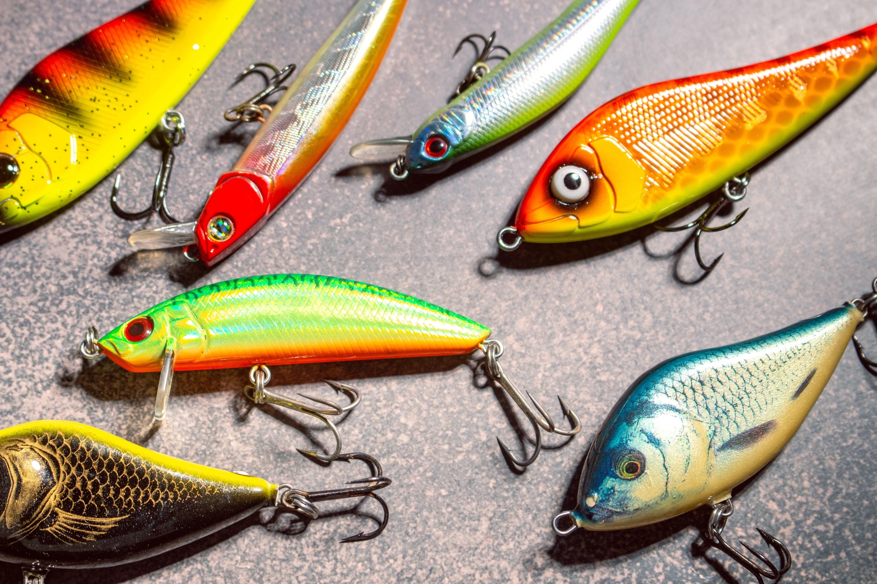 Fishing baits and lures on a wooden background