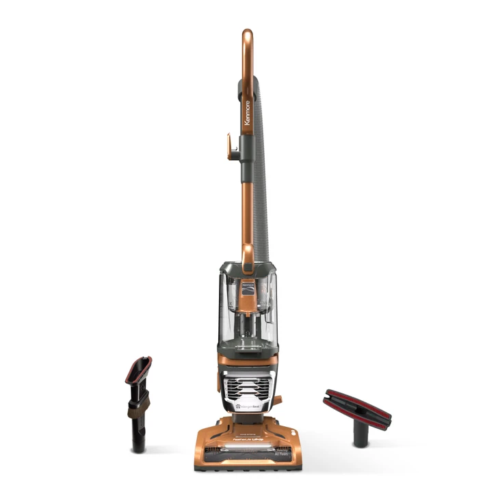 Orange upright vacuum and accessories on a white background