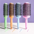 A glamshot of all four colors/sizes of the Ceramic + Ion Blossom Speed XL brushes with matching colored sectioning picks.