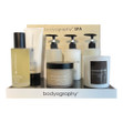 The complete Bodyography Spa Set in a retail display including a shampoo, conditioner, body wash, body scrub, body butter, body oil, and a scented candle. The complete Bodyography Spa Set in a retail display including a shampoo, conditioner, body wash, body scrub, body butter, body oil, and a scented candle.