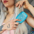 A Glitter UNbrush in the Turquoise color cushion being pulled through dry hair.