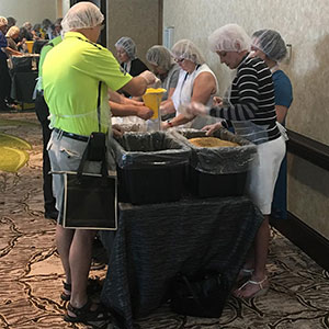 Employees and volunteers making lunches for No Child Hungry.