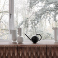 Ferm Living Orb watering can in front of window.