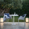 Cane-line Breeze stackable chair in Light Grey outdoors with lamps and other lighting.