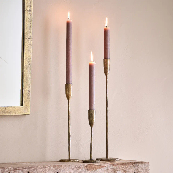Small, medium & large Mbata candlesticks with lit candles.