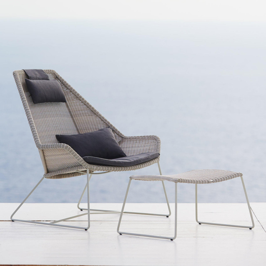 Cane-line Breeze footstool in Light Grey with highback chair by the sea.