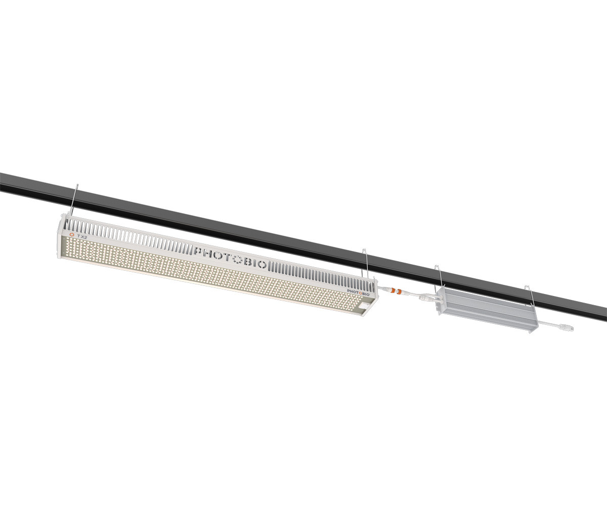 PHOTOBIO TX2 LED grow light fixture suspended by cables, showing linear LED array, white housing, and connected power driver.