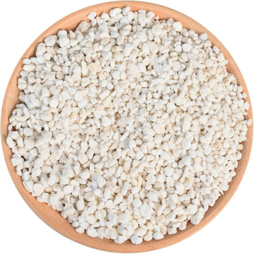 A top-down view of a light-colored wooden bowl filled with coarse white perlite.