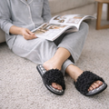 Black curly plush open-toe slippers styled indoors