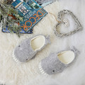 Gray whale house slippers arranged in an indoor setting