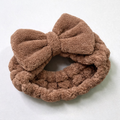 Brown plush bow spa headband on a white background