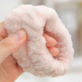 Close-up of the plush texture and elastic opening on a blush spa wristband