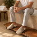 Man wearing beige gathered knit-trim house slippers at home