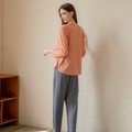Back view of orange cool-touch crewneck top with relaxed drape and straight-leg pants