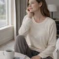 Woman relaxing by a window in beige Essential cool-touch long sleeve lounge set