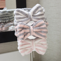 Gray-and-white, pink-and-gray, and pink-and-white striped bow spa headbands displayed vertically