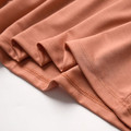 Close-up of soft orange modal fabric and finished hem stitching