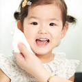 Child holding a white face towel to her cheek