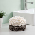 White and gray round hand towels stacked beside a bathroom sink