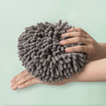 Gray round hand towel displayed over a forearm