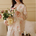 Woman wearing the Pink Still Bloom viscose floral pajama set while holding flowers