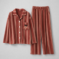 Rust red striped sherpa-lined plush pajama set with button-front top and full-length pants flat lay