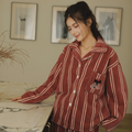 Woman in rust red striped long-sleeve pajama set beside a marble counter