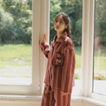 Full-length view of rust red striped plush pajama set with relaxed top and matching pants