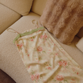 Botanical floral slip nightgown draped over an upholstered chair