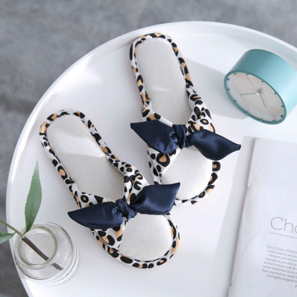 White leopard-print bow open-toe house slippers styled flat lay