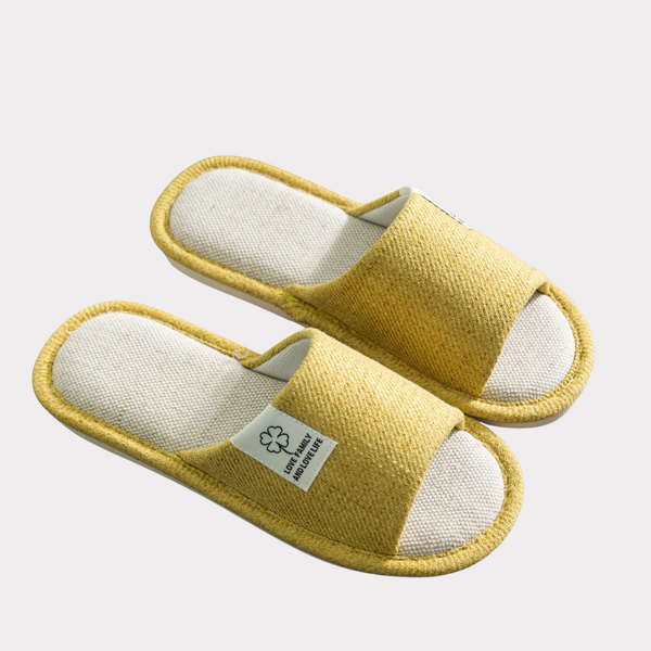 Yellow textured open-toe house slippers on a light background