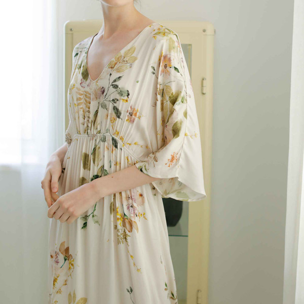 Woman wearing Garden Bloom viscose midi lounge dress with flutter sleeves