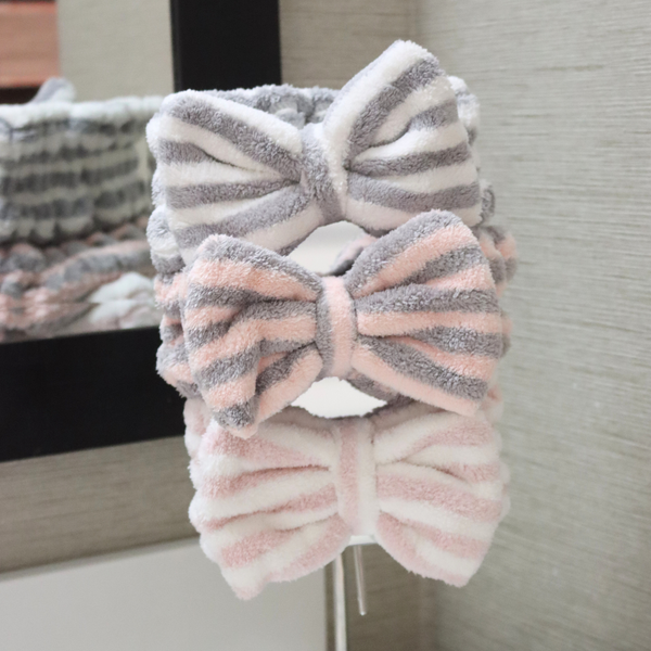 Gray-and-white, pink-and-gray, and pink-and-white striped bow spa headbands displayed vertically