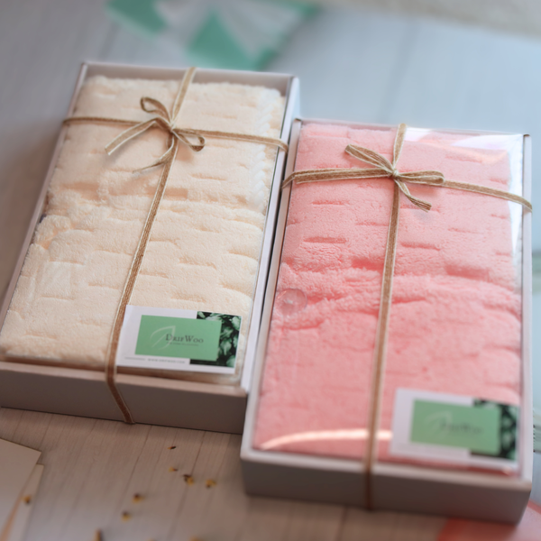 Beige and pink waffle towel sets in ribbon-tied gift boxes