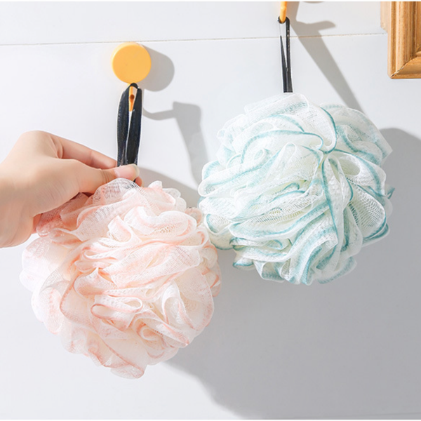 Gentle Peach and Serene Green floral mesh bath poufs on wall hooks