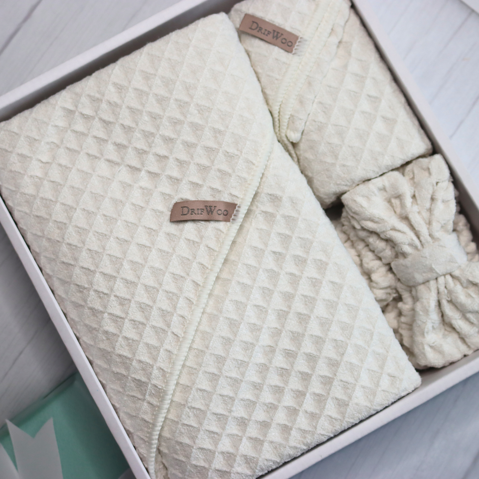 Ivory three-piece waffle towel spa set arranged in an open gift box