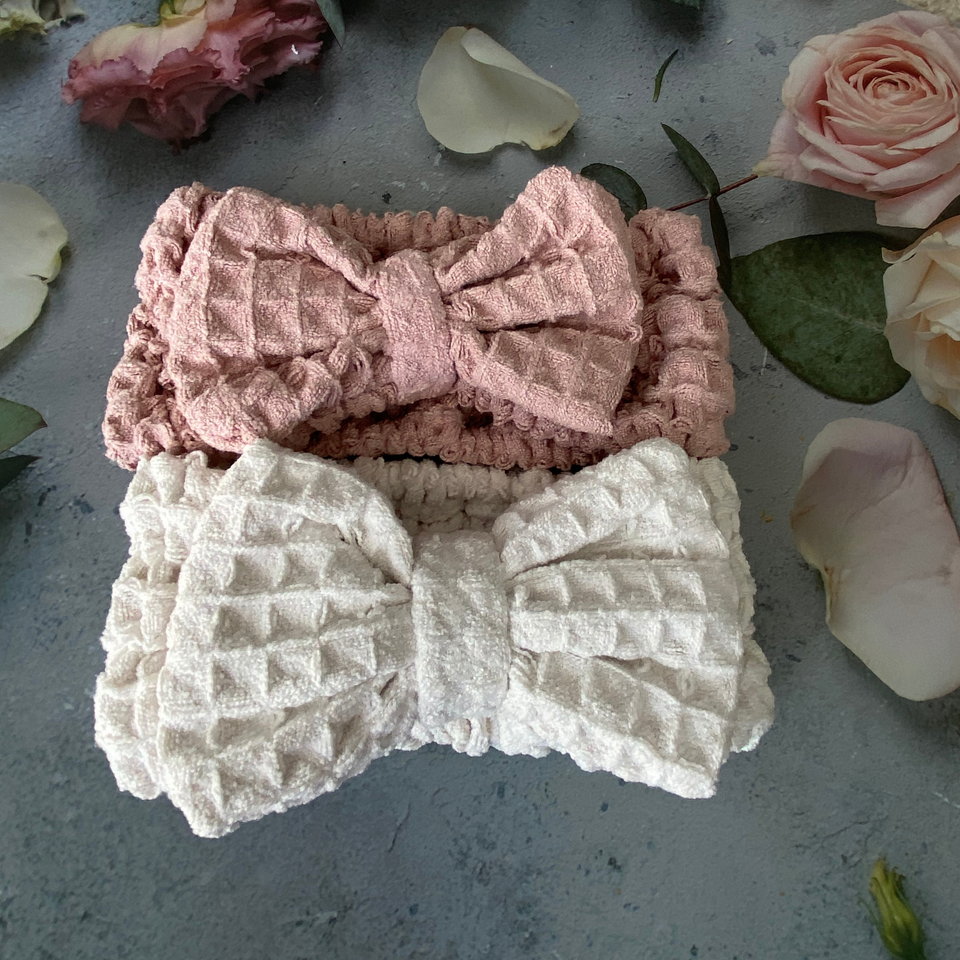 Pink and beige waffle-texture bow spa headbands arranged with flowers