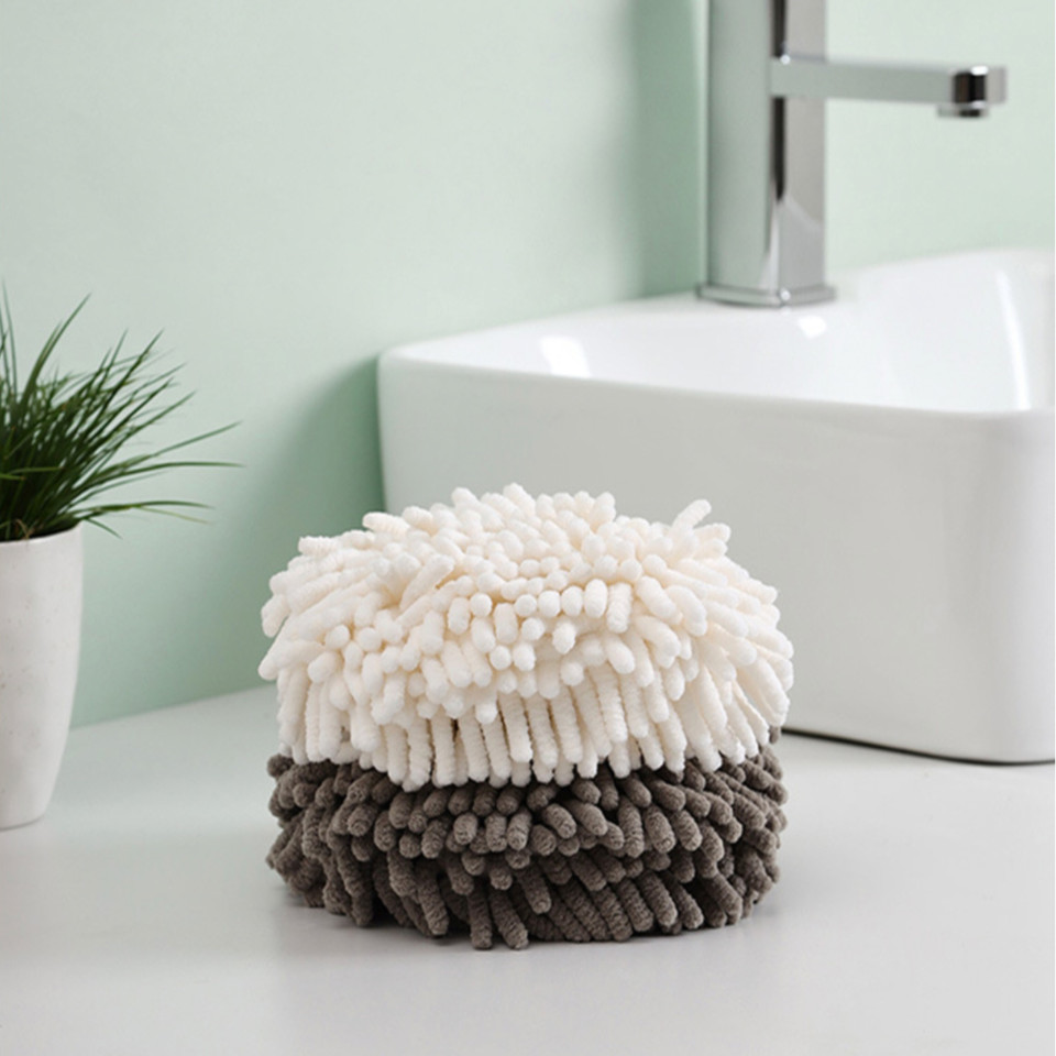 White and gray round hand towels stacked beside a bathroom sink