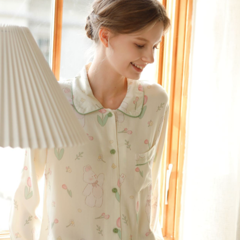 Woman wearing woodland garden bamboo cotton pajama top by a window