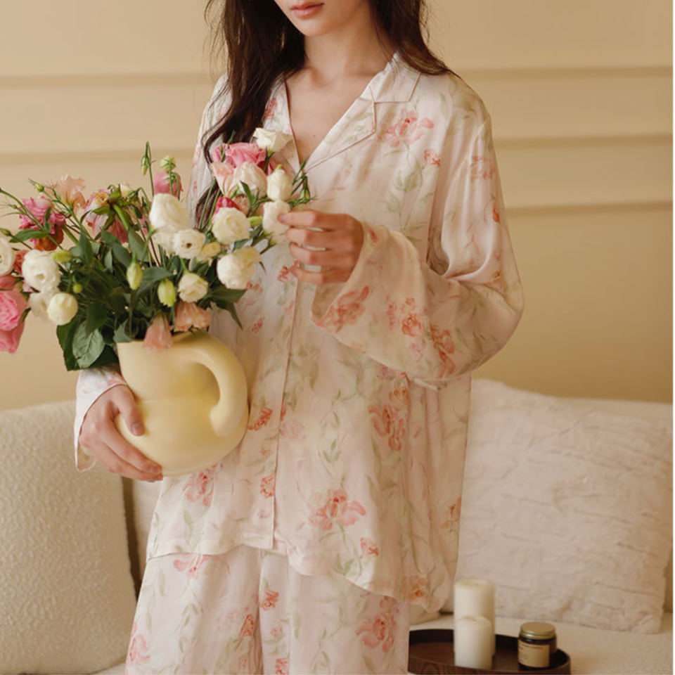 Woman wearing the Pink Still Bloom viscose floral pajama set while holding flowers