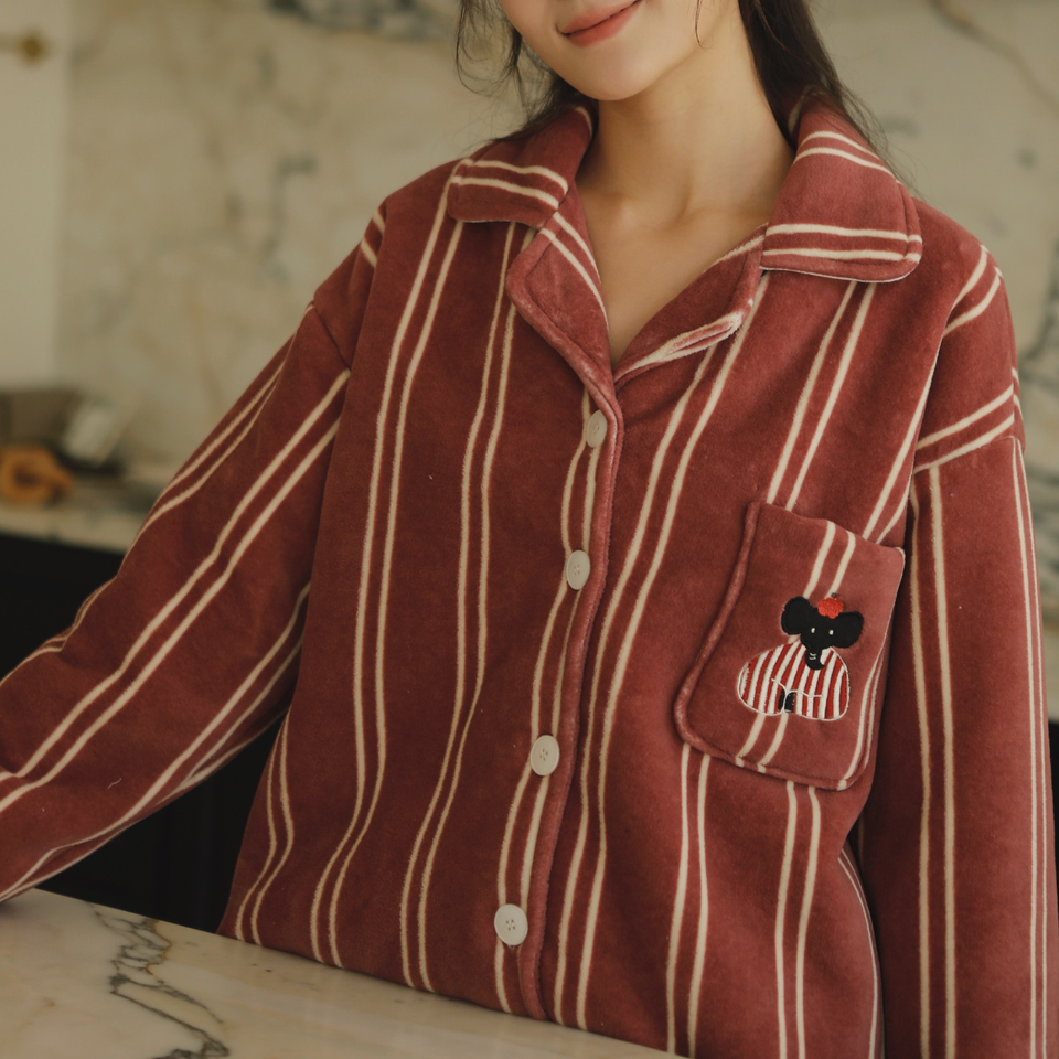 Close-up of soft plush pajama fabric, notched collar, button front, and embroidered pocket