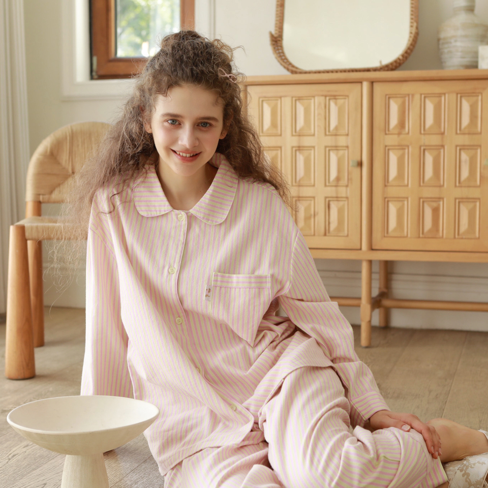 Model wearing Pink striped brushed cotton flannel pajamas while relaxing at home