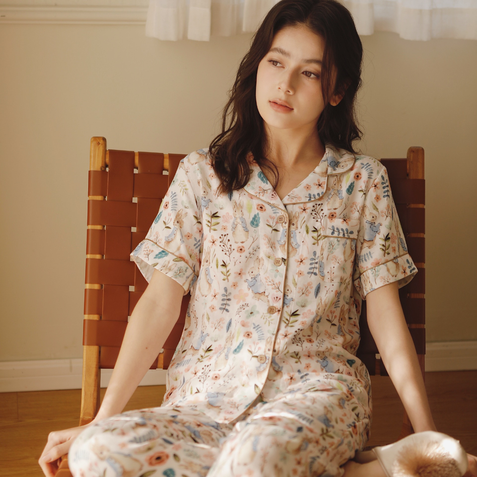 Woman seated in warm light wearing the Meadow Calm pajama set