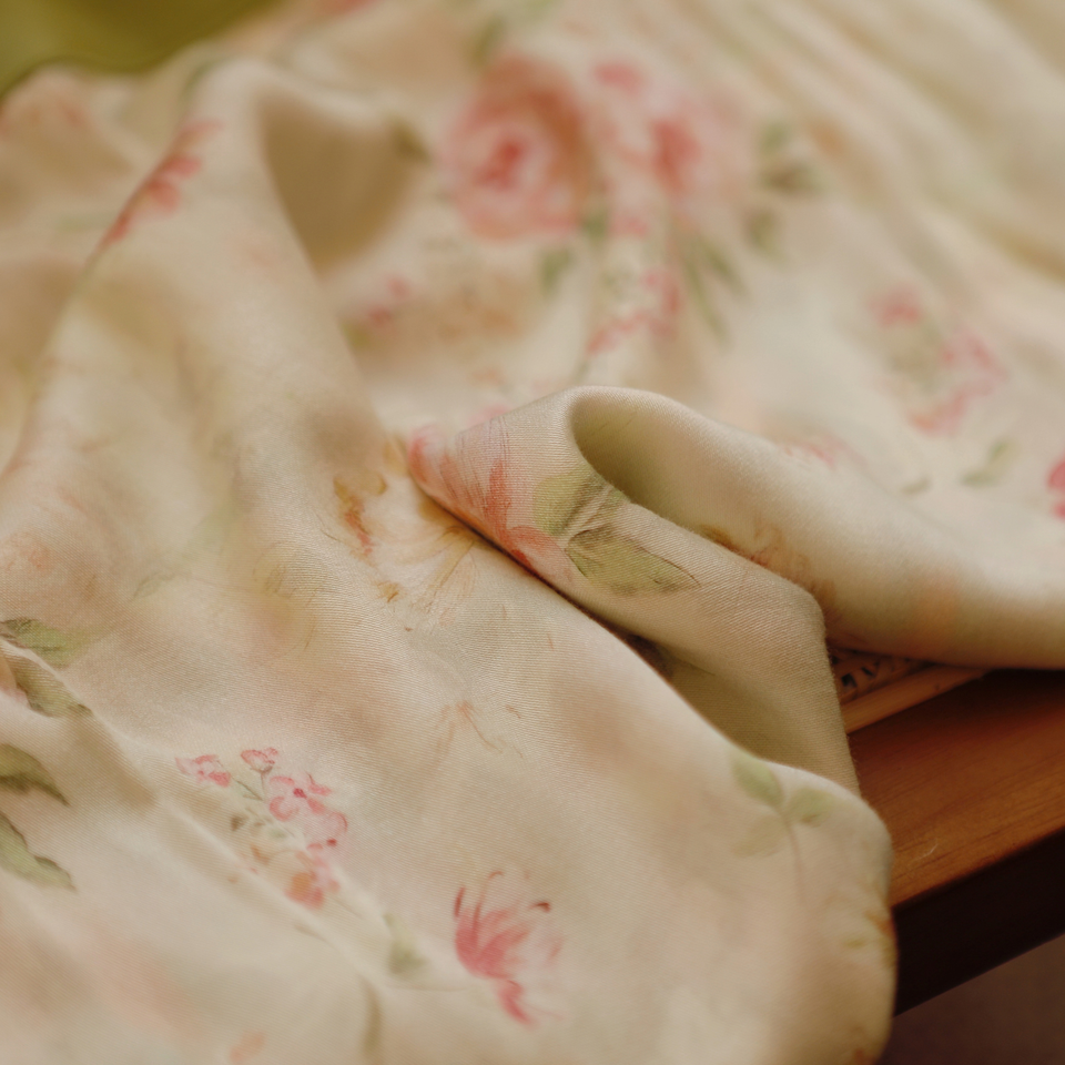 Close-up of the rose and botanical print on ivory viscose fabric