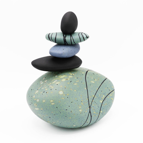 Blown glass cairn sculpture by Melanie Leppla with four glass stones stacked on top of a seafoam base