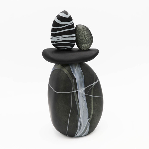 Blown glass cairn sculpture by Melanie Leppla with three glass stones stacked on top of a charcoal base