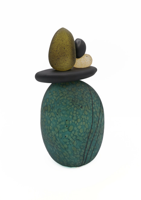 Blown glass cairn sculpture by Melanie Leppla with four glass stones stacked on top of a teal base.