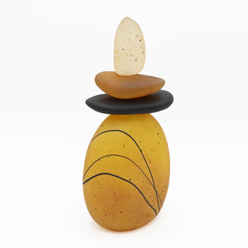 Blown glass cairn sculpture by Melanie Leppla with three glass stones stacked on top of a golden yellow base
